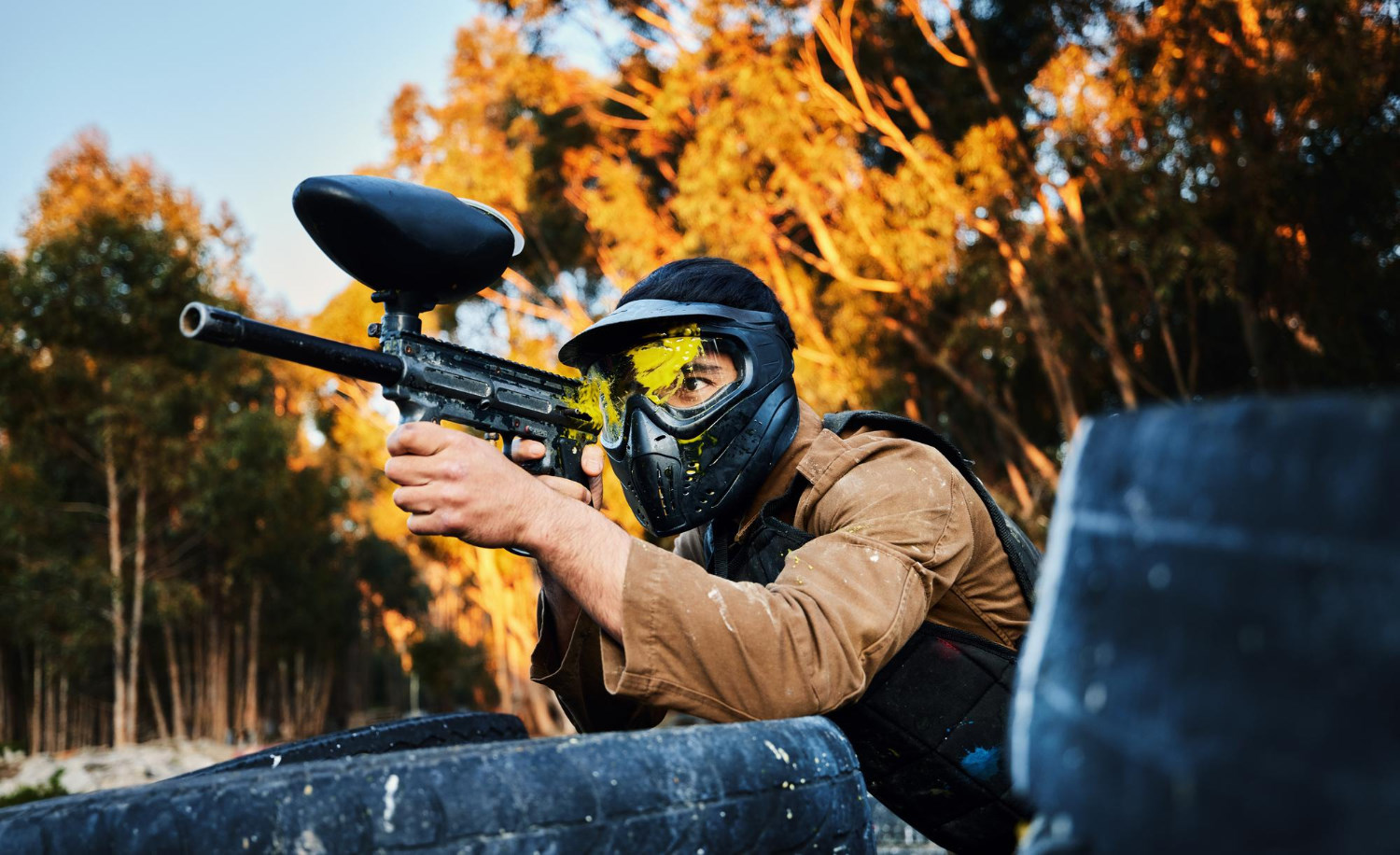 Um jogador de paintball com a marca de tinta na máscara.